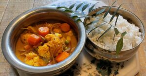 Goan Vegetable Caldinho curry served with rice in Indian handis
