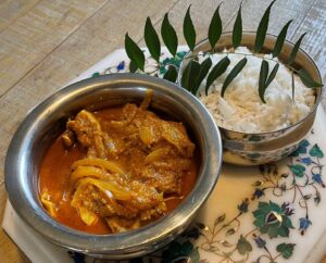 Xacuti Chicken and rice with curry leaves served in traditional Indian handis